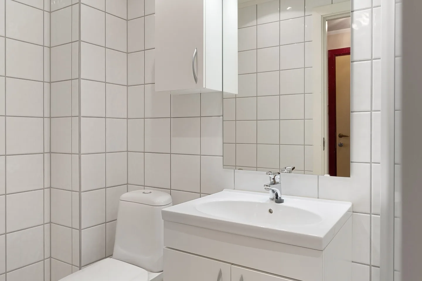 Seramik kaplı modern banyoda lavabo ve duş alanı