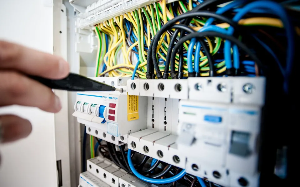 Elektrik panosunda bağlantıları düzenleyen ustanın eli